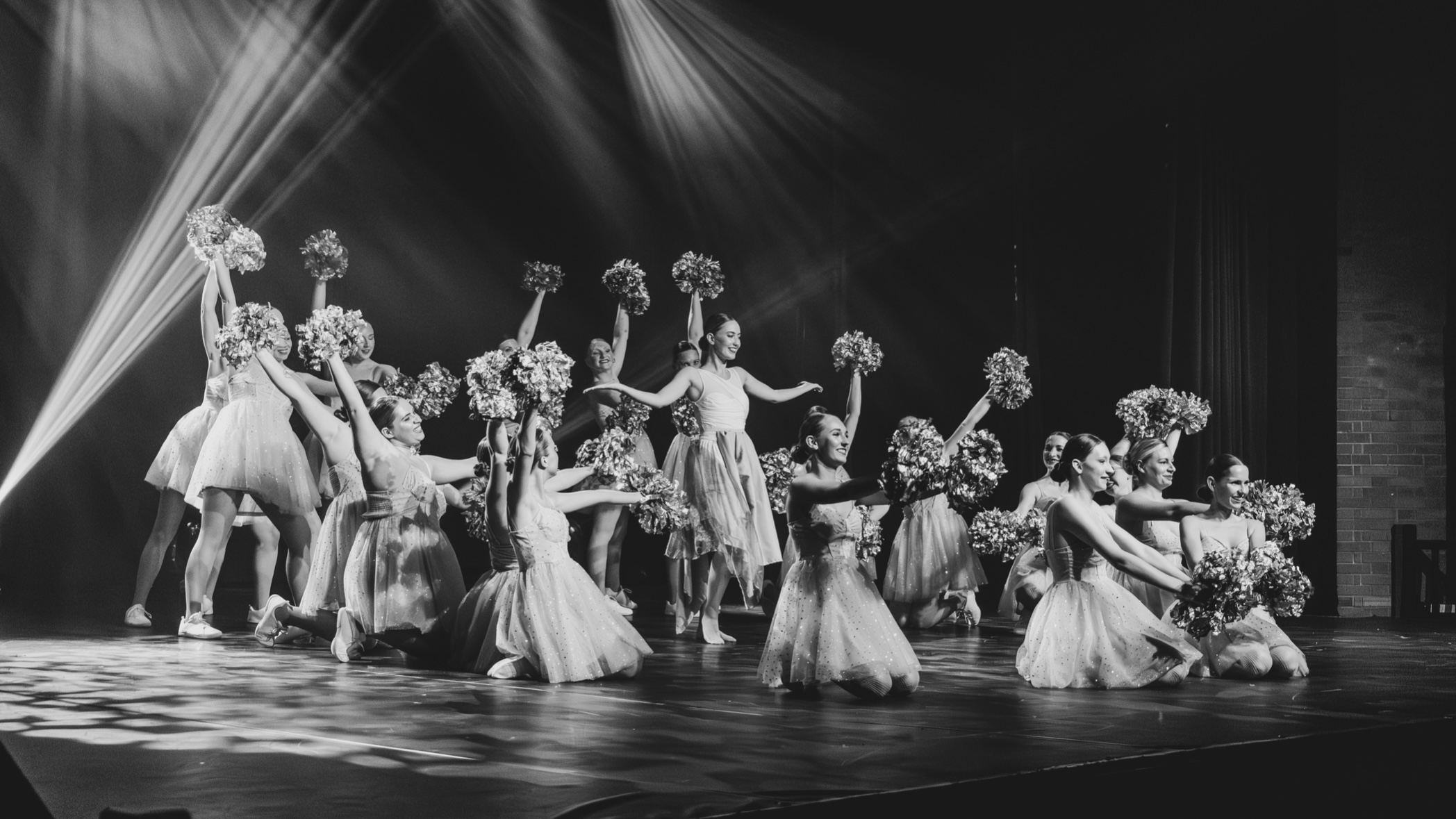 photo de pompom girl en noir et blanc à la fin d'une chorégraphie